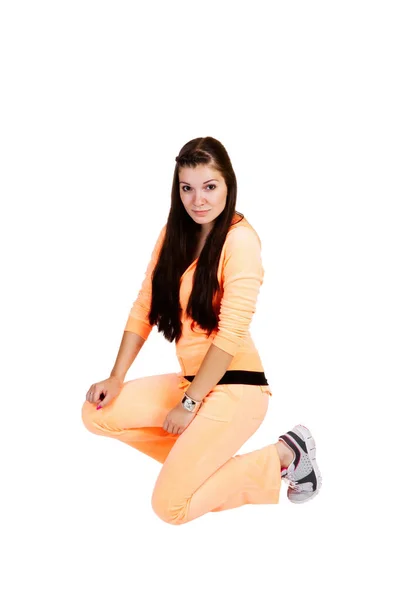 Jong Aantrekkelijk Tiener Vrouw Knielen Oranje Zweet Pak Witte Achtergrond — Stockfoto