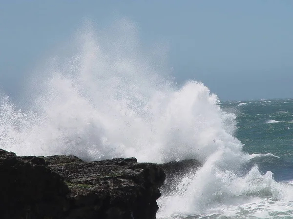 Океанська Хвиля Розлітається Чорному Береговому Скелі Блакитним Небом — стокове фото