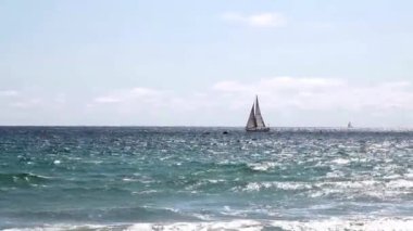 Okyanus Dalgaları ve Mavi Gökyüzü Yelkenli Yelkenli ve Beyaz Bulutlu