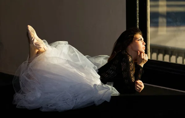Atrakcyjna Młoda Kobieta Stroju Tanecznym Leżąca Brzuchu Wyglądająca Przez Okno — Zdjęcie stockowe