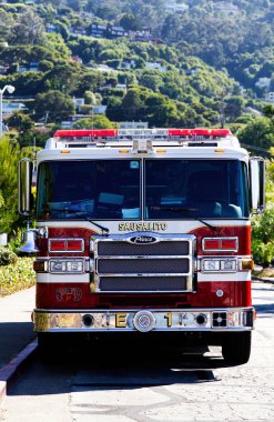 Arka planda yeşil ağaçlarla park edilmiş Sausalito California itfaiye aracı görüldü.