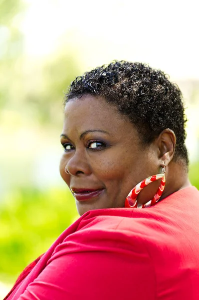年上のアフリカ系アメリカ人女性 赤いジャケットを身に着けている アウトドア 肩越しに見える肖像画 — ストック写真