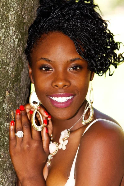 アウトドア肖像画魅力的な若いアフリカ系アメリカ人女性は木の笑顔に傾いています — ストック写真