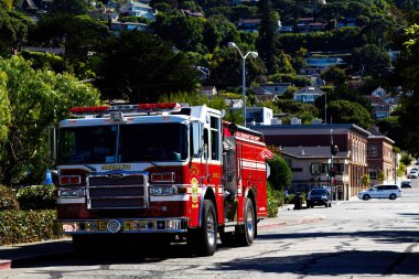 Sausalito California 'da, arka planında yeşil ağaçlar ve binalar olan bir itfaiye aracı park etmiş.
