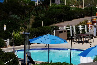 Kaliforniya 'nın arka planında okyanus kıyısında küçük bir yüzme havuzu ve zemin.