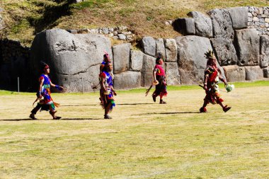 Inti Raymi Festivali 'nde Renkli Geleneksel Kostüm Giyen Adamlar Güney Amerika Cusco Peru' da Arka planda İnka Taş Duvarları olan deniz kabukları taşıyor