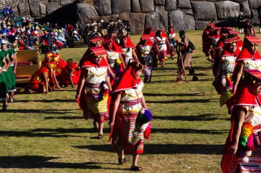 İnti Raymi Festivali Cusco Peru Güney Amerika Erkekler ve Kadınlar Arka planda İnka Taş Duvarı olan geleneksel kostümler giyiyor
