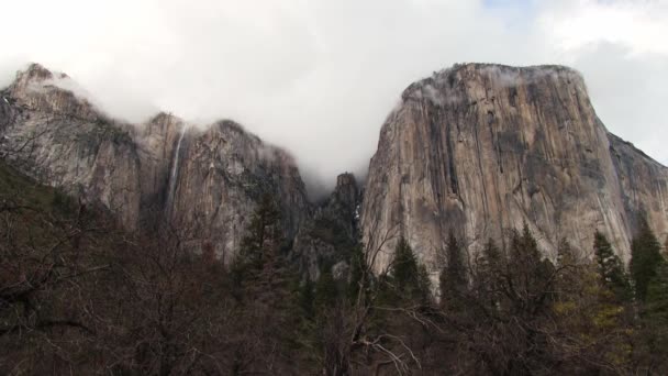雲と冬の木ヨセミテ国立公園カリフォルニア州との滝の遠隔ショット — ストック動画