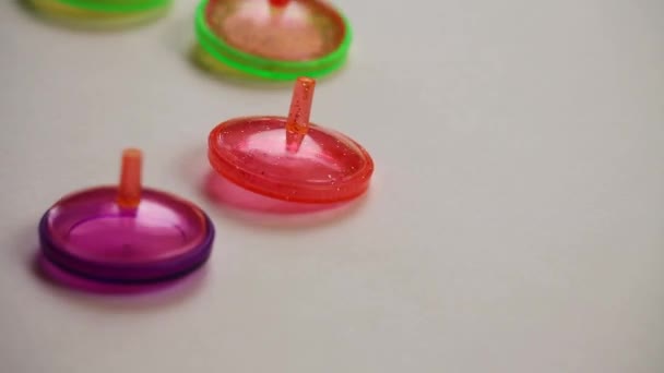 Bunte Plastik Spielzeugoberteile Drehen Sich Von Oben Auf Hellgrauem Hintergrund — Stockvideo