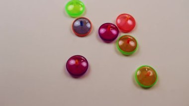 Colorful Small Plastic Tops Spinning Viewed From Above On White Surface