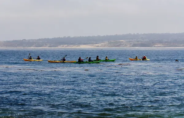 背景为加州蒙特利湾黄绿相间的独木舟 图库照片