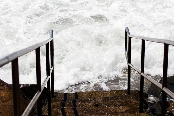 海浪到达了通往加利福尼亚滨海的台阶的底部 图库图片