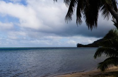 Güney Pasifik Okyanusu üzerinde beyaz bulutlar Moorea Fransız Polinezyası Ağaç Kumsalı ve Kara