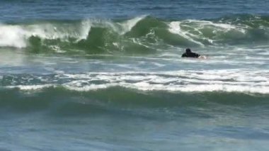 Dalgıç kıyafetli sörfçü Okyanus Dalgaları 'nda, Kaliforniya' da kürek çekiyor.