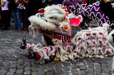 Marysville, California, United States - March 5, 2011: Chinese Lion Dancer Sitting On Cobble Stone Street In Parade clipart