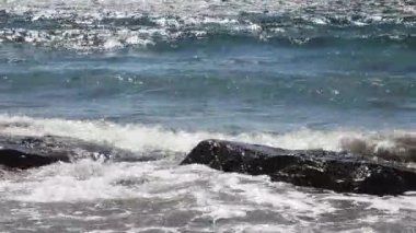 Mavi gökyüzü ve Kaliforniya Bulutları ile Kayaların Üzerindeki Okyanus Dalgaları 'nın El Çekimi