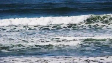 Dalgıç kıyafetli iki adam Kuzey Kaliforniya 'da sörf tahtalarında dalgaların arasında yüzüyor. 