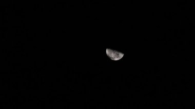 Half Moon In Night Sky With Moving Clouds Obscuring It