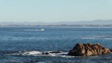 Kamera Monterey Körfezi 'nde hareket eden motorlu tekneyi takip ediyor. Arka planda sis var.