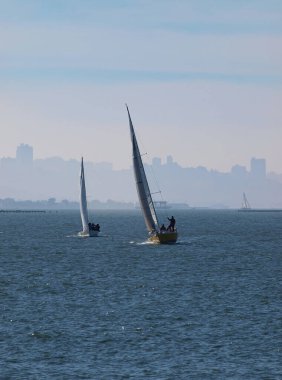 İki yelkenli yelkenli San Francisco körfezinde Şehirli Haze 'nin arkasında
