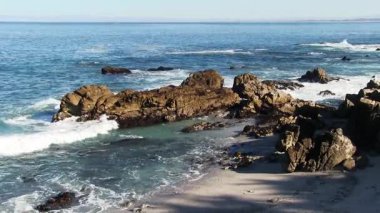 Okyanus dalgaları kayalara çarpıyor ve Monterey Körfezi 'ndeki Monterey Körfezi Kaliforniya' ya akıyor.