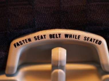 Uçak koltuğu koltuğunun arkasındaki mesaj otururken kemerlerinizi bağlayın.