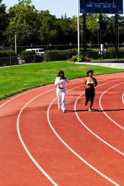 İki Afrikalı Amerikalı Kadın Güneş Işığı Pistinde Yürüyor ve Koşuyor