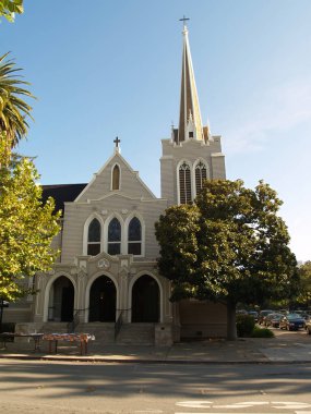 Ön kapı kemerleri ve çan kulesi Yeşil ağaçlar ve mavi gökyüzü olan eski kilise.