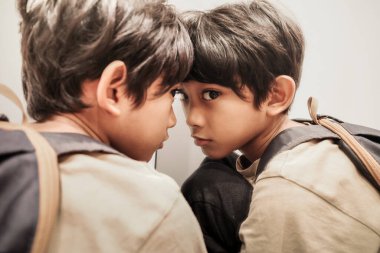 A Southeast Asian Boy Sitting in Front of a Mirror with Bored Expression and Eyes Staring clipart