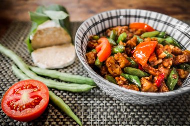 Lezzetli Endonezya öğle yemeği menüsü kızarmış tempeh ve çalı fasulyesi masada servis ediliyor.