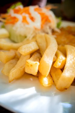 Close-up plate of fish and chips menu with salad served as lunch meal at a restaurant clipart