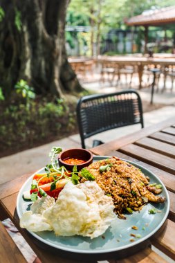 Lezzetli ve ünlü Endonezya geleneksel kırmızı biber soslu pilav ve açık hava restoranında öğle yemeği için servis edilen taze sebzeler.