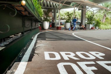 Yolcular, bir ofis binasının ana lobisine giden araç yoluna işaret bırakıyorlar.