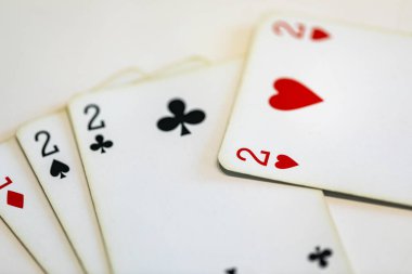 Beyazların arka planında iskambil oynayan dört çift. 2 numaralı poker kartı.