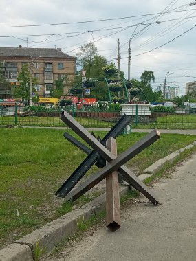 KYIV, UKRAINE - 19 Mayıs 2022: Polesye yönünde Kyiv 'in eteklerindeki bir çiçek tarlasının arka planına karşı tanksavar engelleri. Ukrayna 'daki Rus saldırısına direniş