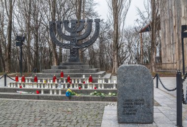 Kyiv, UKRAINE-28, Ocak 2025: Babi Yar Menorah anıtı, arkasında Ukrayna 'nın başkenti Kyiv' de sembolik bir sinagog bulunan Yahudi Soykırımı Anma Günü onuruna anıt ve taşlar ile.