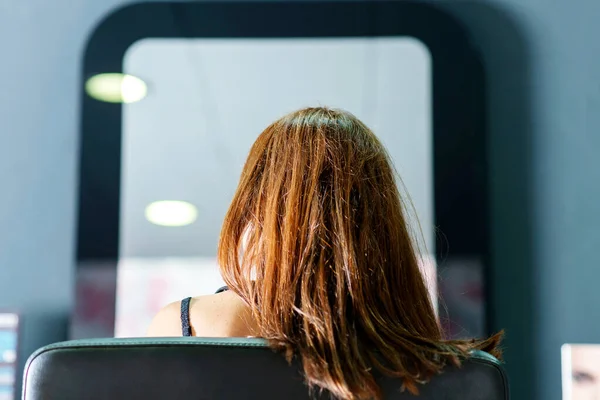 理发师的工作场所 染色和理发内容 头发分开的女人正坐在发廊的椅子上 镜子里有倒影 一个女人来整理她的头发 — 图库照片