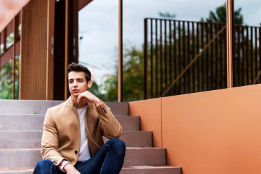 Merdivenlerde montlu şık bir gencin portresi.