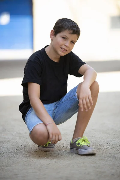 Boy Shorts Black Shirt Crouching While Looking Camera Outdoors — Stock Photo, Image