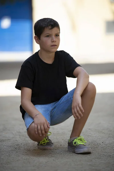 Jongen Korte Broek Zwart Shirt Hurken Terwijl Hij Naar Camera — Stockfoto