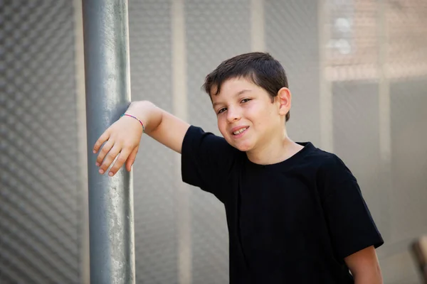 Chłopiec Spodenkach Czarny Shirt Opierający Się Ścianie Zewnątrz Patrząc Kamerę — Zdjęcie stockowe