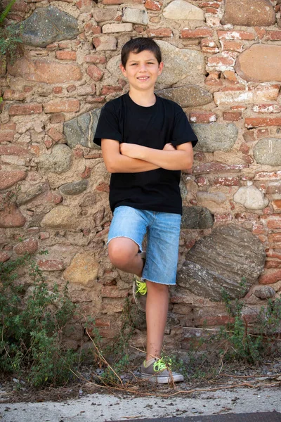 Boy Shorts Black Shirt Leaning Wall Outdoors While Looking Camera — Stock Photo, Image
