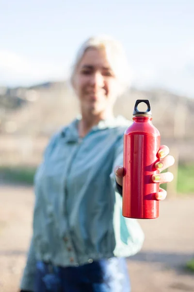 Счастливая Улыбающаяся Спортсменка Передает Бутылку Водой Камеру — стоковое фото