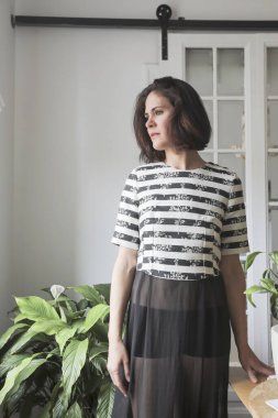 Gizemli kızıl saçlı kadın pencerenin yanındaki odada aşkı bekliyor. İlham arayan kız yazar.