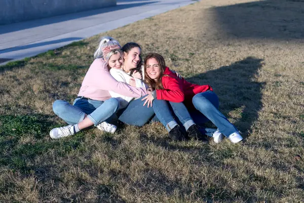 Tres Amigos Disfrutan Momento Relajado Sentados Hierba Tomando Sol Compartiendo Fotos de stock
