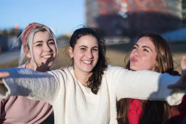 Três Mulheres Jovens Sorriem Livre Braços Estendidos Uma Pose Despreocupada Fotografia De Stock
