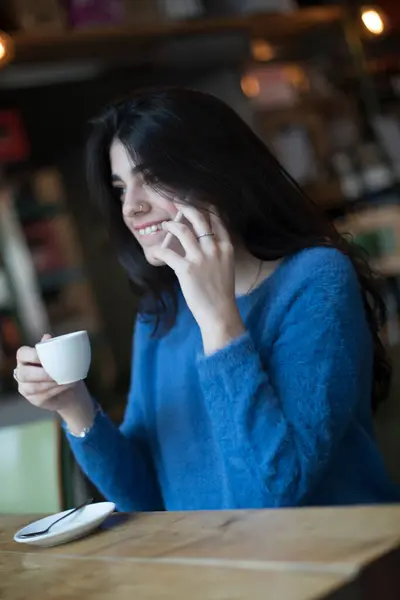Młoda Kobieta Ciemnych Włosach Ubrana Niebieski Sweter Rozmawia Przez Telefon Obrazy Stockowe bez tantiem
