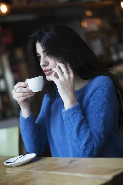 Młoda Kobieta Ciemnych Włosach Ubrana Niebieski Sweter Rozmawia Przez Telefon Zdjęcia Stockowe bez tantiem