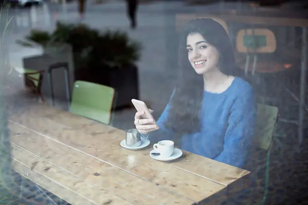 Молода Жінка Синьому Светрі Фокусується Своєму Телефоні Кафе Чашкою Кави Стокове Зображення