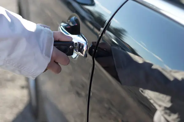 Arabanın Anahtarlarını Anahtarlığını Tutan Bir Kamerası Parlak Bir Arabanın Kapısını Stok Resim